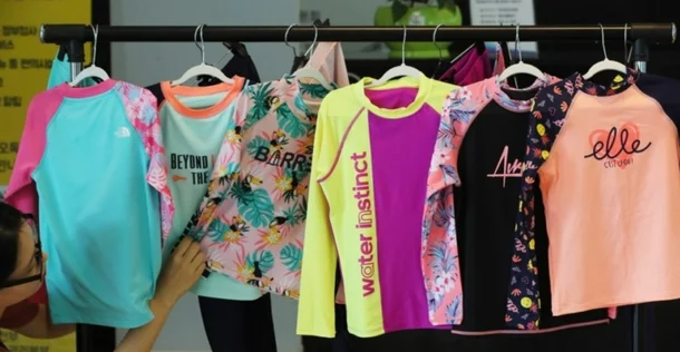 Koreans wearing rash guardsswimwear' 'display' 'hangers' 'clothing.
