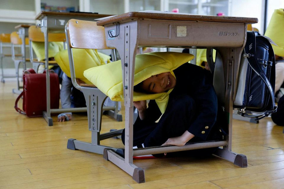 Japan mega earthquake preparednessschoolboy-desk-hiding-classroom.